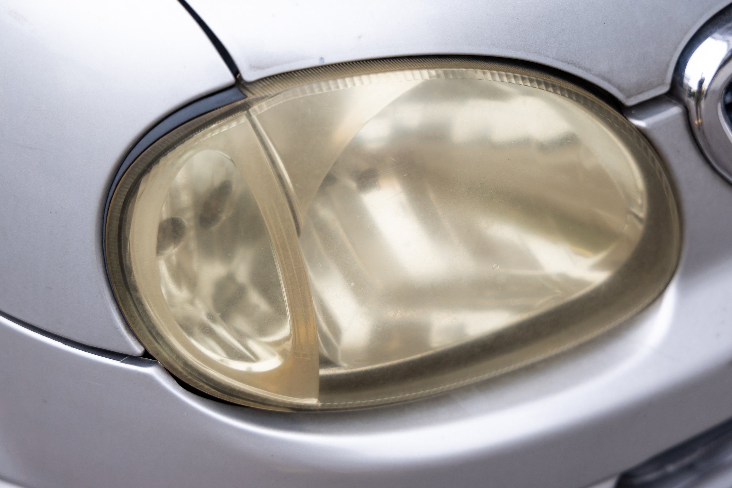 Hazy, yellowed car headlight that reduces light output and night driving visibility